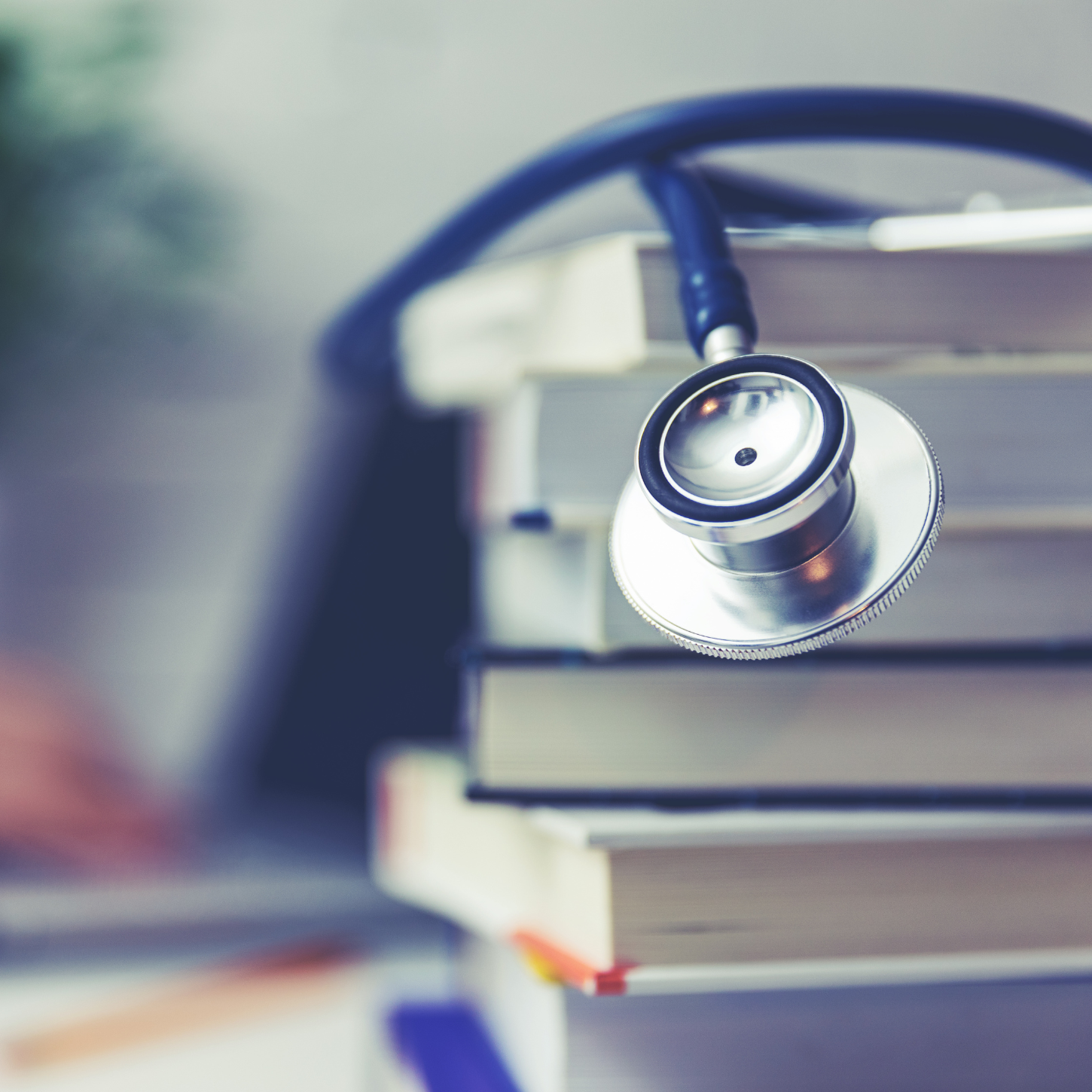 Stack of books with stethoscope draped over